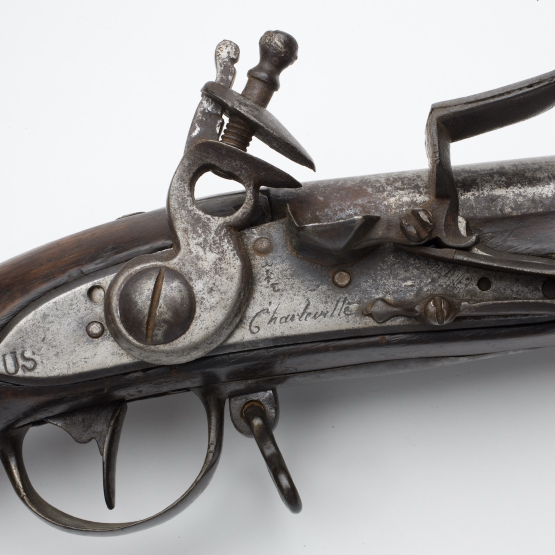 The lock of a Charleville musket, showing French and American marks, illustrates details used to interpret artifacts of the Revolutionary War.